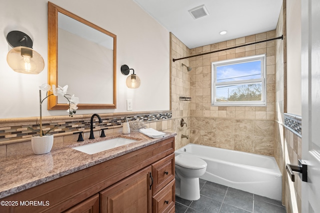 full bathroom featuring tile patterned floors, visible vents, toilet, tile walls, and  shower combination