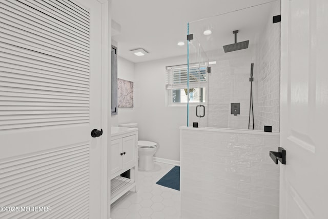 bathroom with tile patterned flooring, baseboards, toilet, a stall shower, and vanity