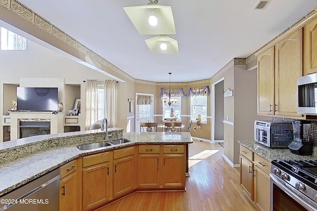 kitchen with a healthy amount of sunlight, appliances with stainless steel finishes, visible vents, and a sink