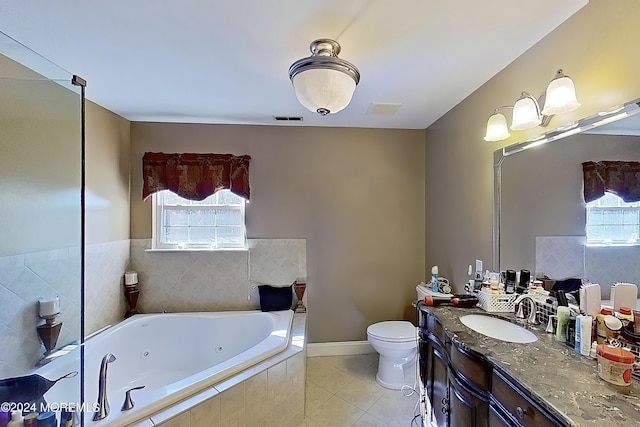 bathroom with tile patterned flooring, plenty of natural light, vanity, and a whirlpool tub