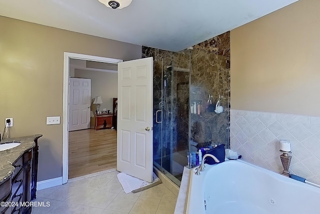 bathroom featuring a stall shower, a jetted tub, vanity, and tile patterned floors