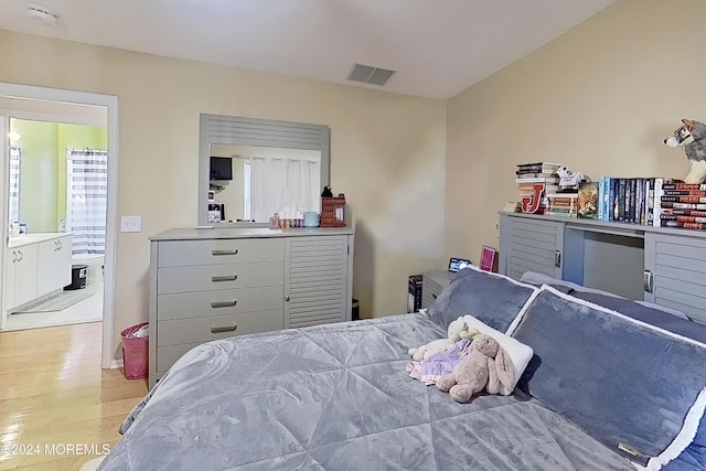 bedroom with light wood-style floors and visible vents