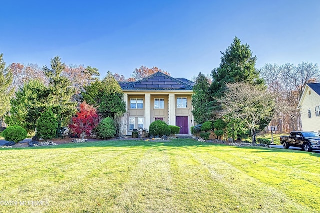 greek revival house featuring board and batten siding and a front yard