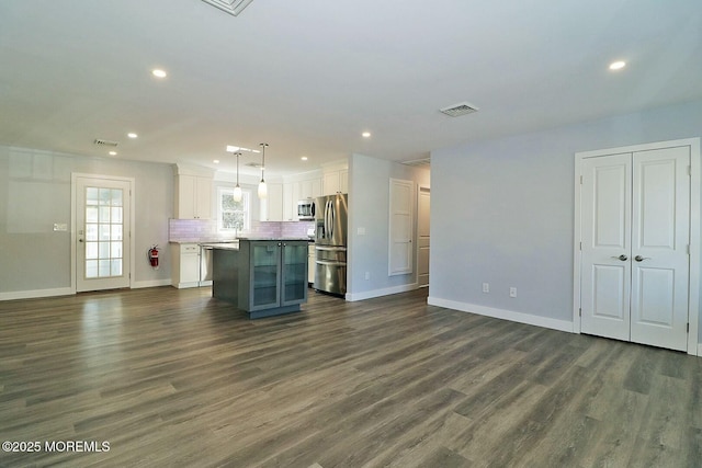 kitchen with white cabinetry, open floor plan, appliances with stainless steel finishes, a center island, and decorative light fixtures