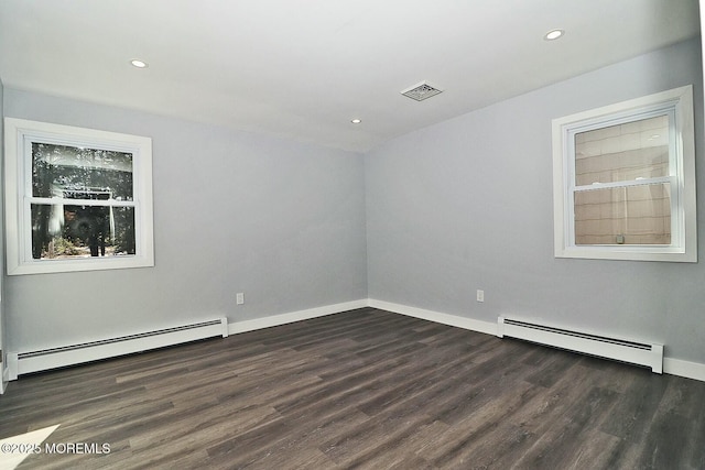 empty room with visible vents, baseboard heating, dark wood finished floors, and recessed lighting