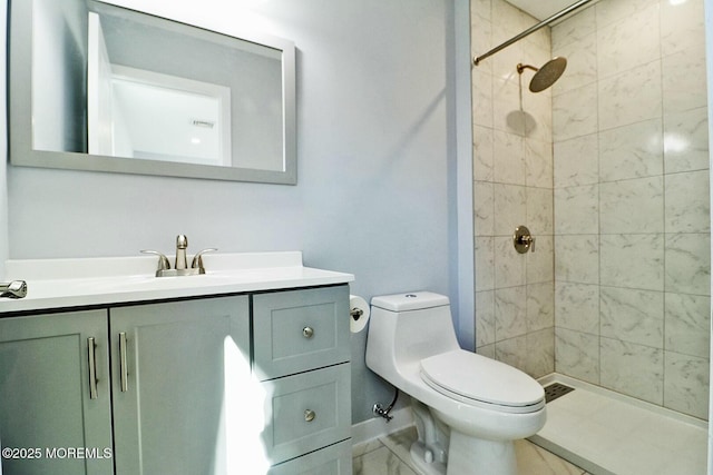 bathroom featuring toilet, marble finish floor, a stall shower, and vanity