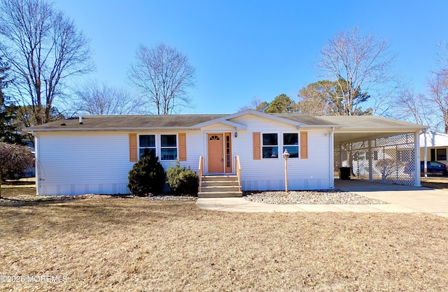 ranch-style house featuring a carport, entry steps, concrete driveway, and a front lawn