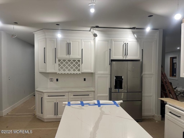 kitchen featuring white cabinets, light stone countertops, pendant lighting, and stainless steel fridge with ice dispenser