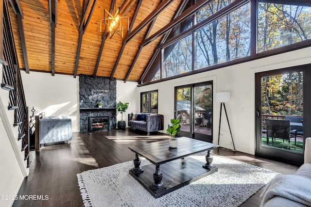 living area featuring beam ceiling, wood ceiling, a stone fireplace, wood finished floors, and high vaulted ceiling