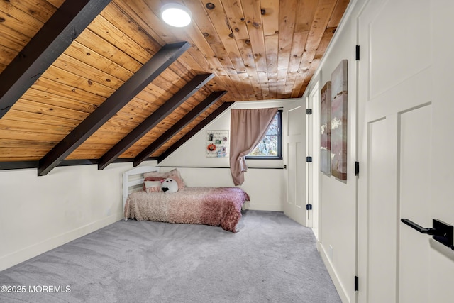 unfurnished bedroom featuring lofted ceiling with beams, carpet, wood ceiling, and baseboards