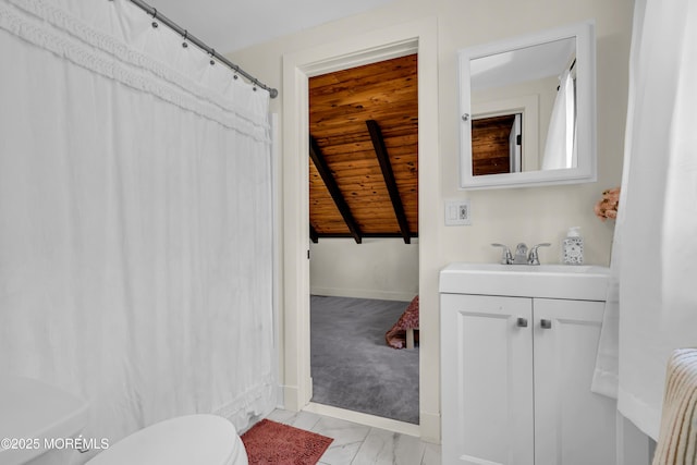 bathroom featuring toilet, marble finish floor, baseboards, and vanity