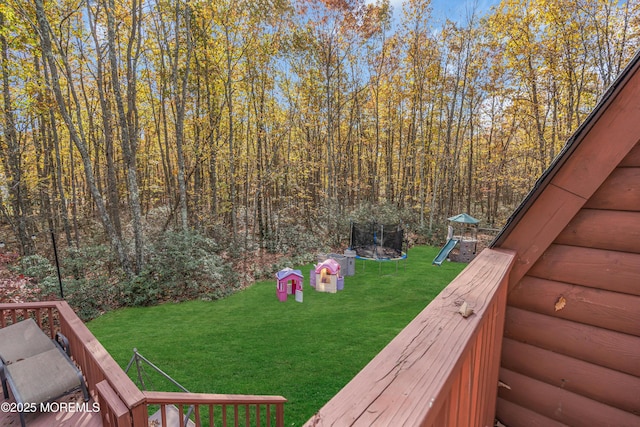 view of yard with a trampoline and a playground