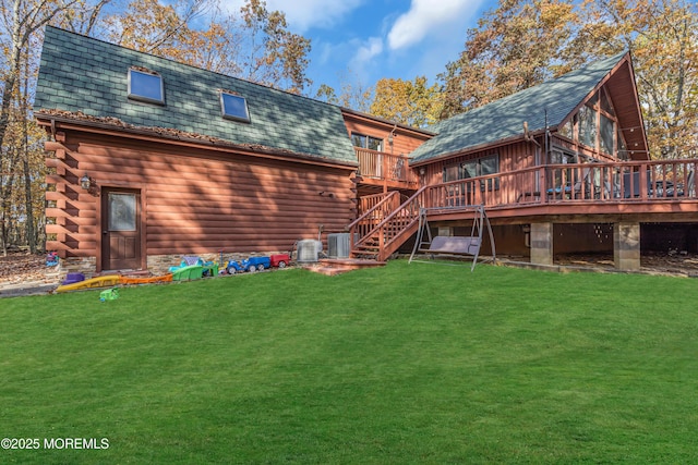 rear view of house with stairway, a yard, a deck, and log siding