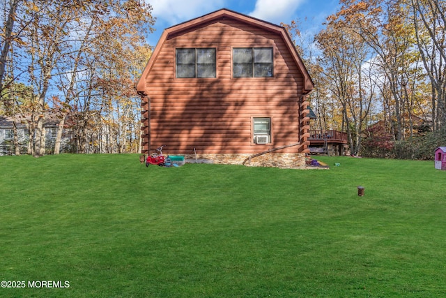 view of home's exterior featuring a deck, cooling unit, a gambrel roof, a yard, and log siding