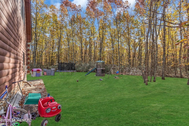 view of yard with a trampoline and a playground