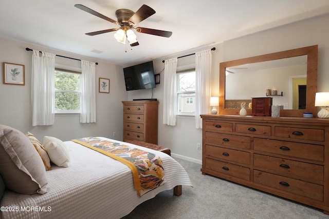 bedroom featuring light colored carpet, ceiling fan, and baseboards