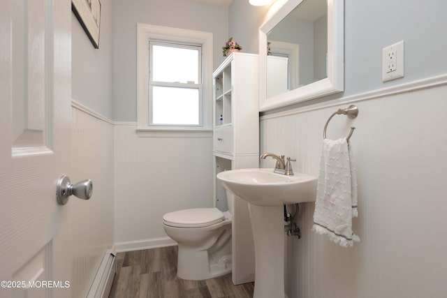 bathroom featuring a baseboard radiator, a wainscoted wall, toilet, and wood finished floors