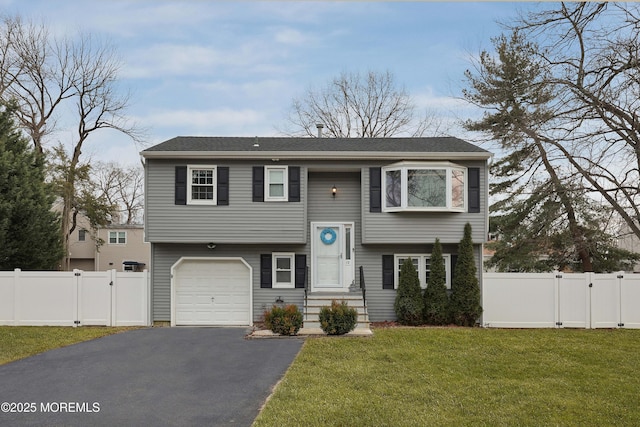 split foyer home with aphalt driveway, a front yard, a gate, and fence