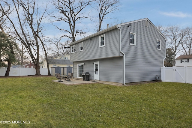 rear view of house featuring a patio, a lawn, and a fenced backyard