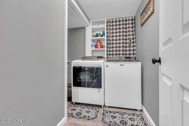 washroom featuring laundry area, washing machine and dryer, and baseboards