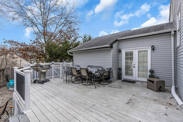 wooden terrace featuring french doors and outdoor dining area