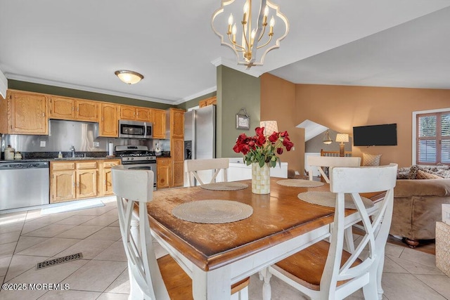 dining area with light tile patterned floors, ornamental molding, and a chandelier