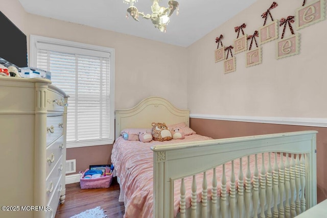 bedroom featuring visible vents, multiple windows, a chandelier, and wood finished floors