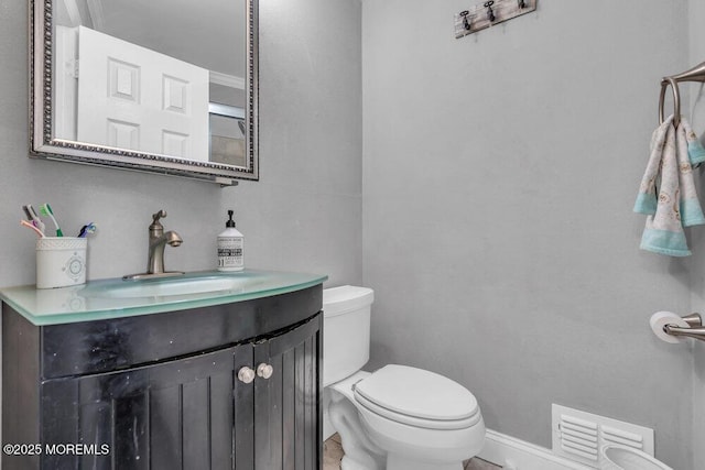 bathroom with toilet, visible vents, and vanity