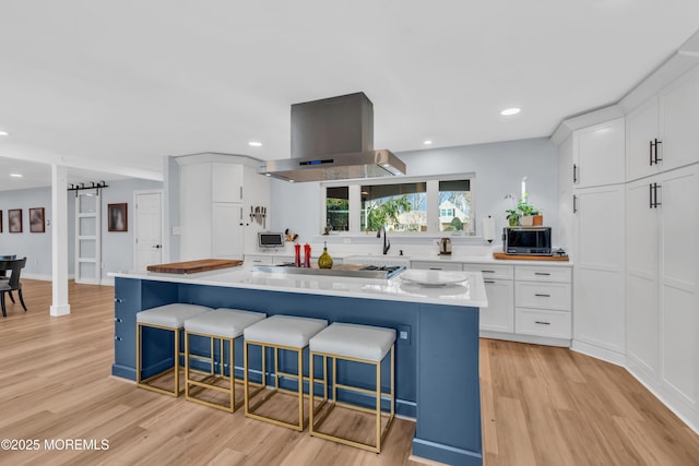 kitchen with light countertops, island exhaust hood, and white cabinets