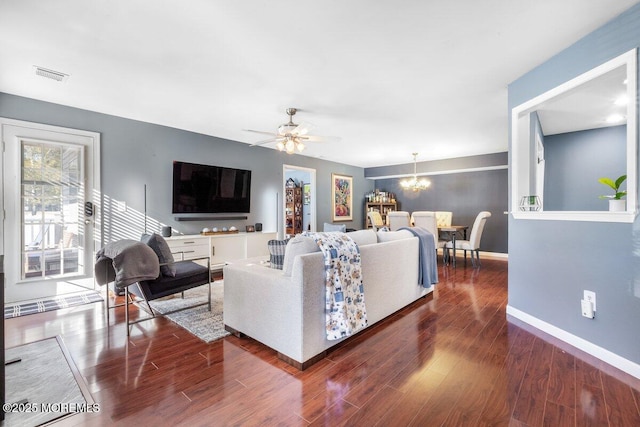 living room with visible vents, baseboards, dark wood finished floors, and ceiling fan with notable chandelier