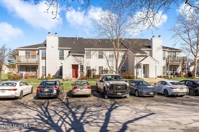 view of building exterior featuring uncovered parking and a residential view