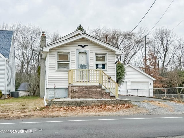 bungalow-style house with central AC unit, a chimney, and a detached garage