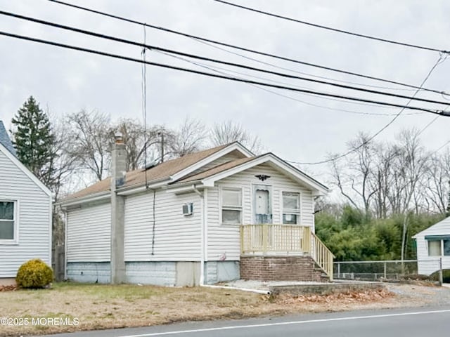 bungalow featuring fence and a chimney