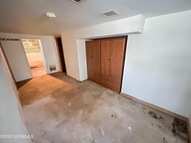 unfurnished bedroom with a closet, visible vents, and unfinished concrete flooring