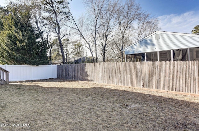 view of yard featuring a sunroom and a fenced backyard