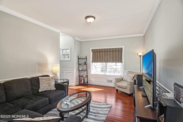 living room featuring visible vents, ornamental molding, wood finished floors, and wainscoting