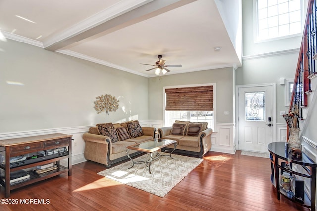 living room featuring a healthy amount of sunlight, a wainscoted wall, wood-type flooring, and ceiling fan