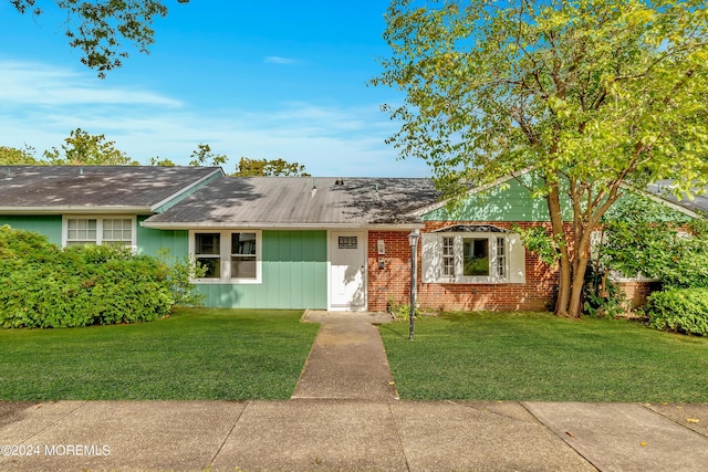 ranch-style home with a front lawn and brick siding