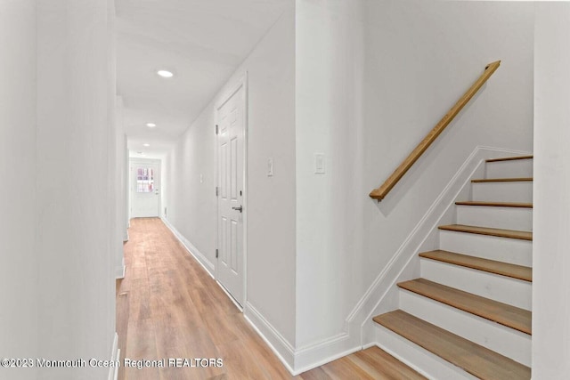 staircase featuring recessed lighting, wood finished floors, and baseboards