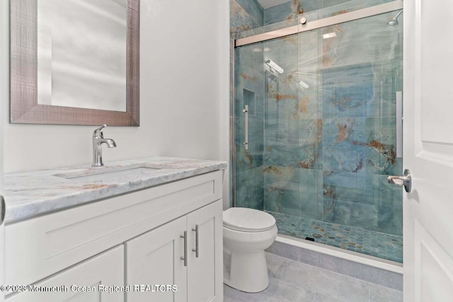 full bath with tile patterned flooring, a shower stall, vanity, and toilet