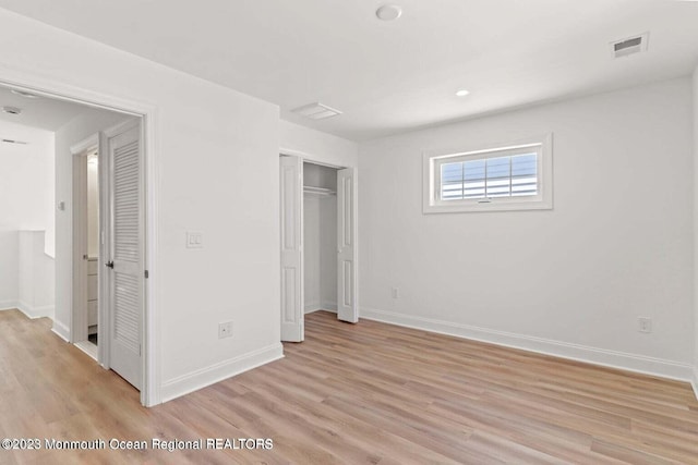 unfurnished bedroom with light wood finished floors, a closet, visible vents, and baseboards