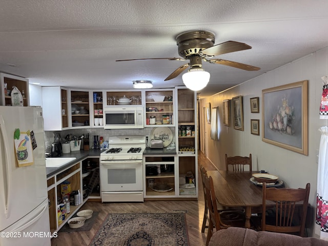 kitchen featuring dark wood-type flooring, white appliances, ceiling fan, and a textured ceiling