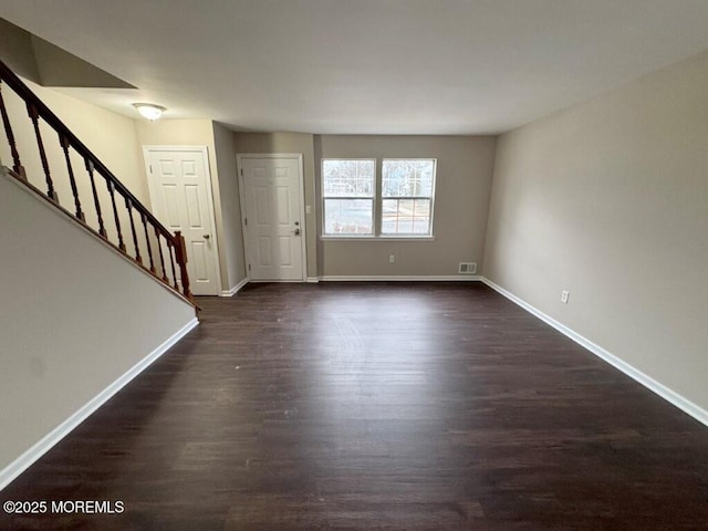 interior space with stairs, baseboards, and dark wood finished floors