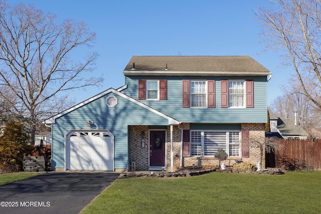 colonial-style house with aphalt driveway, a garage, brick siding, fence, and a front lawn