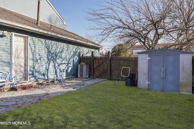 view of yard with a storage unit, central AC unit, an outdoor structure, and fence