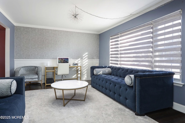 living room with wainscoting, crown molding, and wallpapered walls