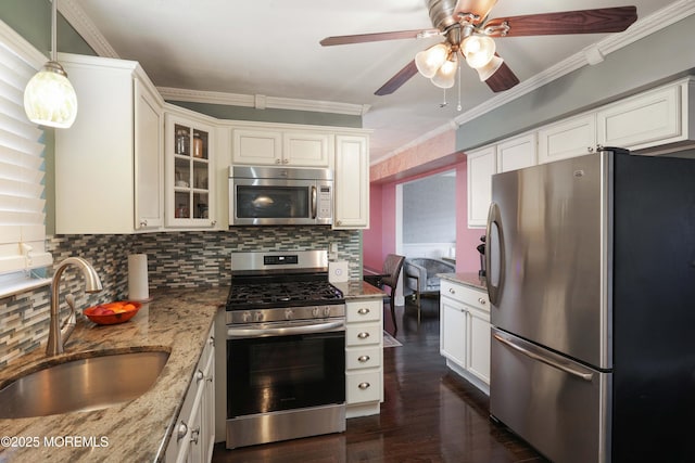 kitchen with appliances with stainless steel finishes, white cabinets, glass insert cabinets, and a sink