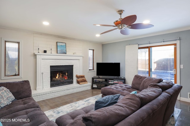 living area featuring ornamental molding, recessed lighting, a fireplace, and wood finished floors