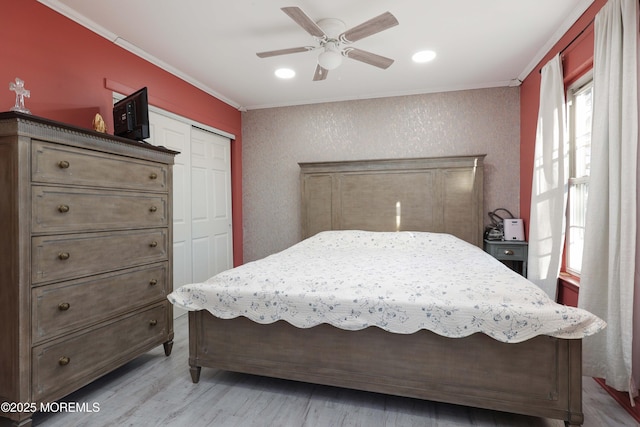 bedroom with recessed lighting, a ceiling fan, a closet, light wood finished floors, and crown molding