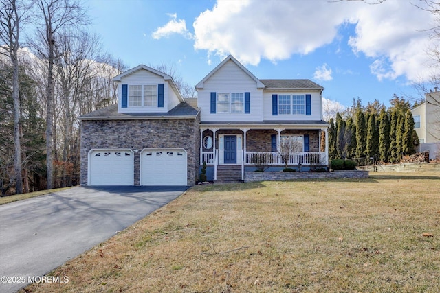 traditional-style house featuring covered porch, stone siding, a front lawn, and aphalt driveway